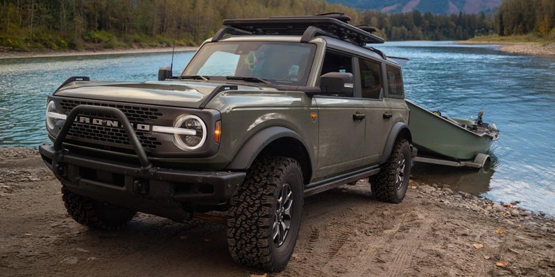 Ford Bronco parked by a river, representing a vehicle maintenance program benefit.