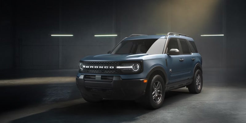 Dark blue Ford Bronco Sport SUV, front 3/4 view, parked in a dimly lit garage.
